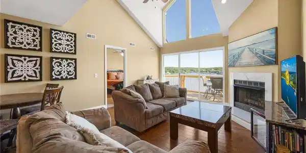 Image 2: Bright and airy living room featuring soaring vaul