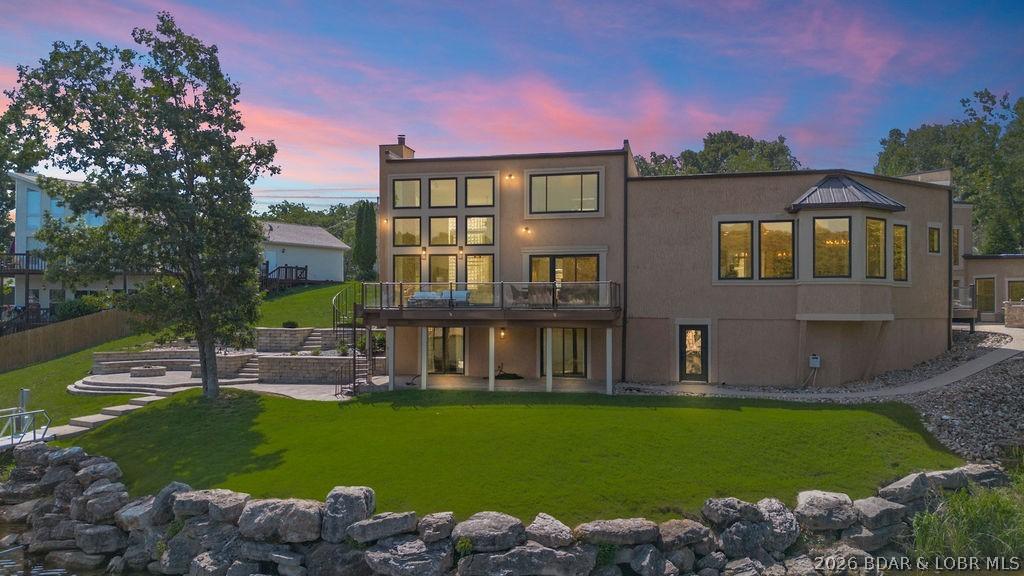 Image 1: Rear view of property from the water. Large deck o