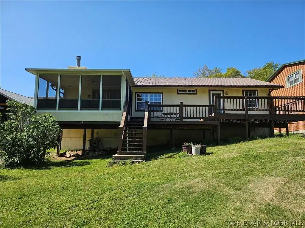 Image 1: Lakeside view of the house.  Sun room is on the le