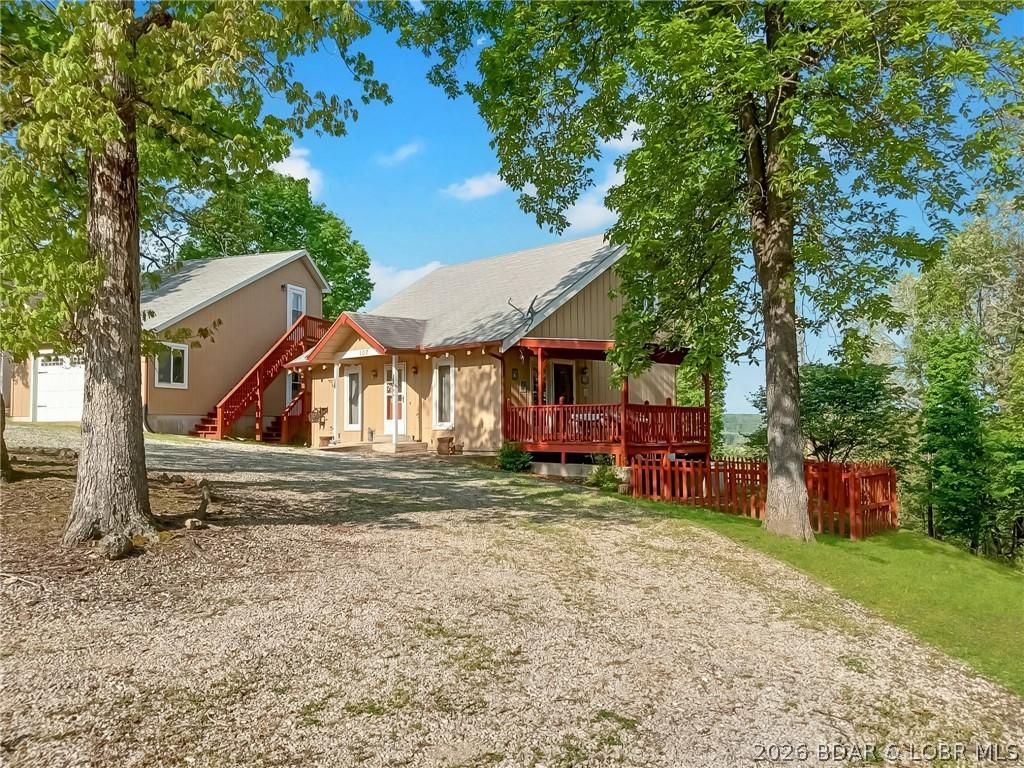 Image 3: Parking and side covered deck and fenced yard.