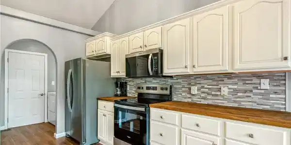 Image 4: The kitchen has been updated with new cabinetry, c