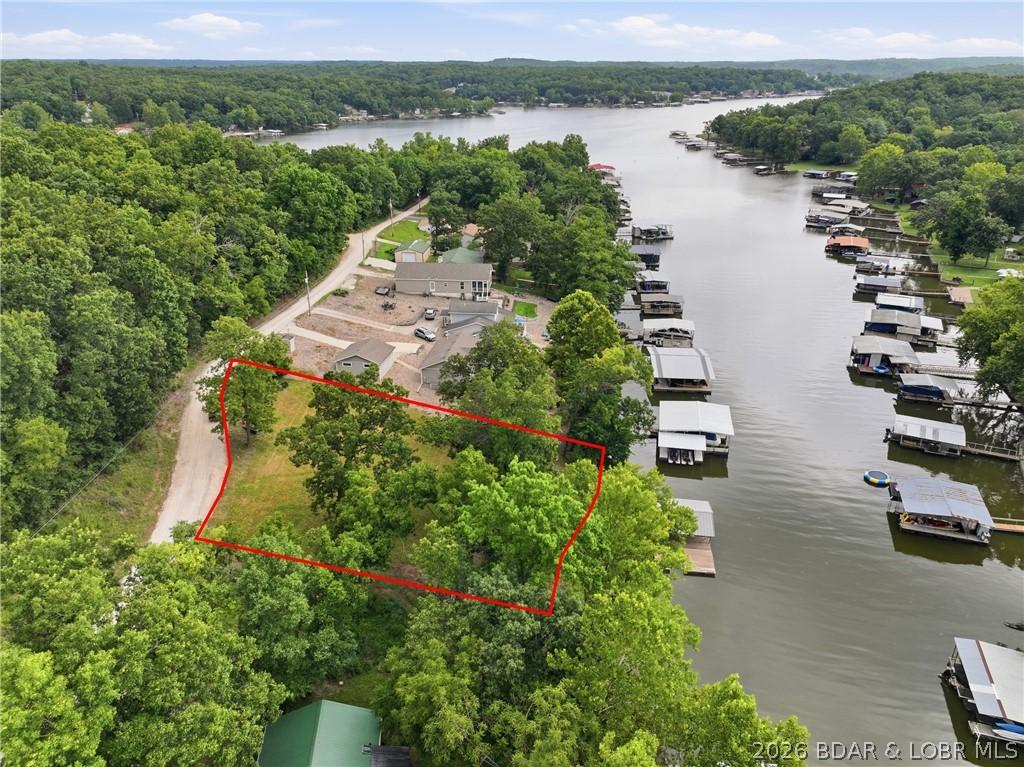 Image 1: Aerial view highlighting the level, wooded lot wit