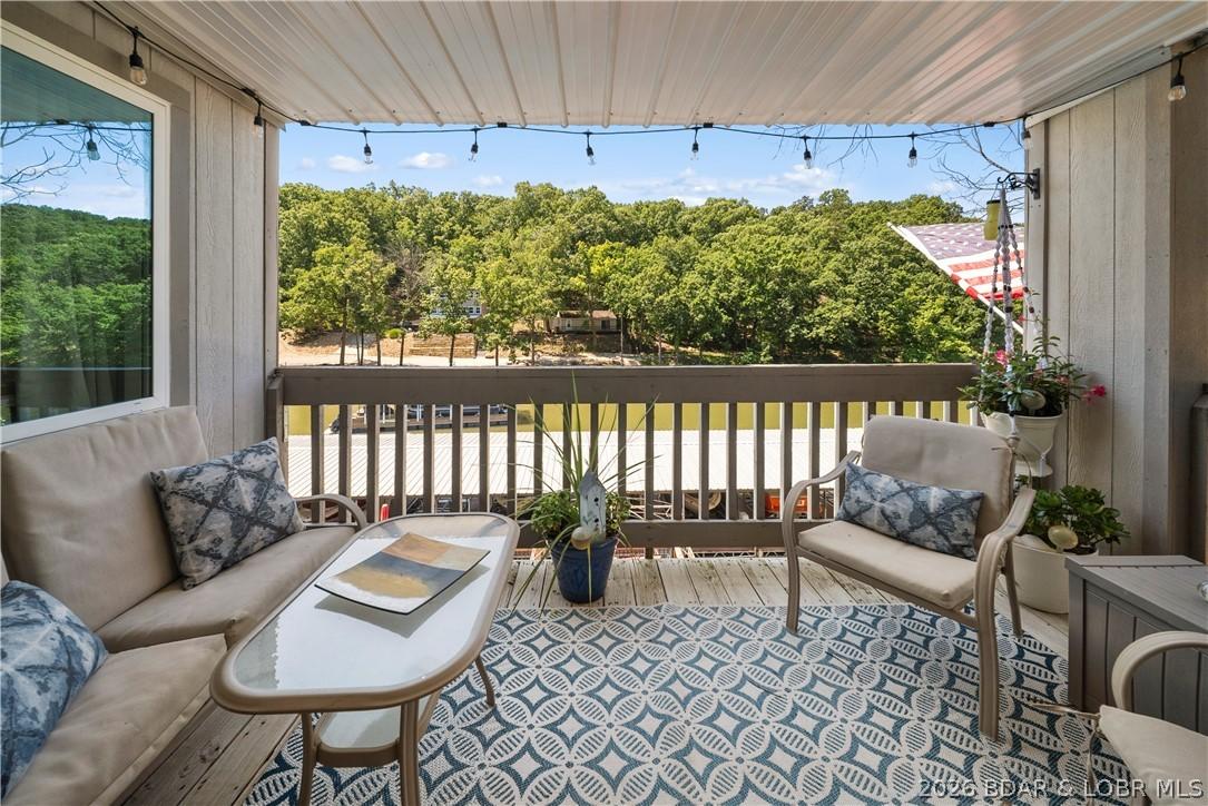 Image 1: A cozy covered deck overlooking the pool and lake!