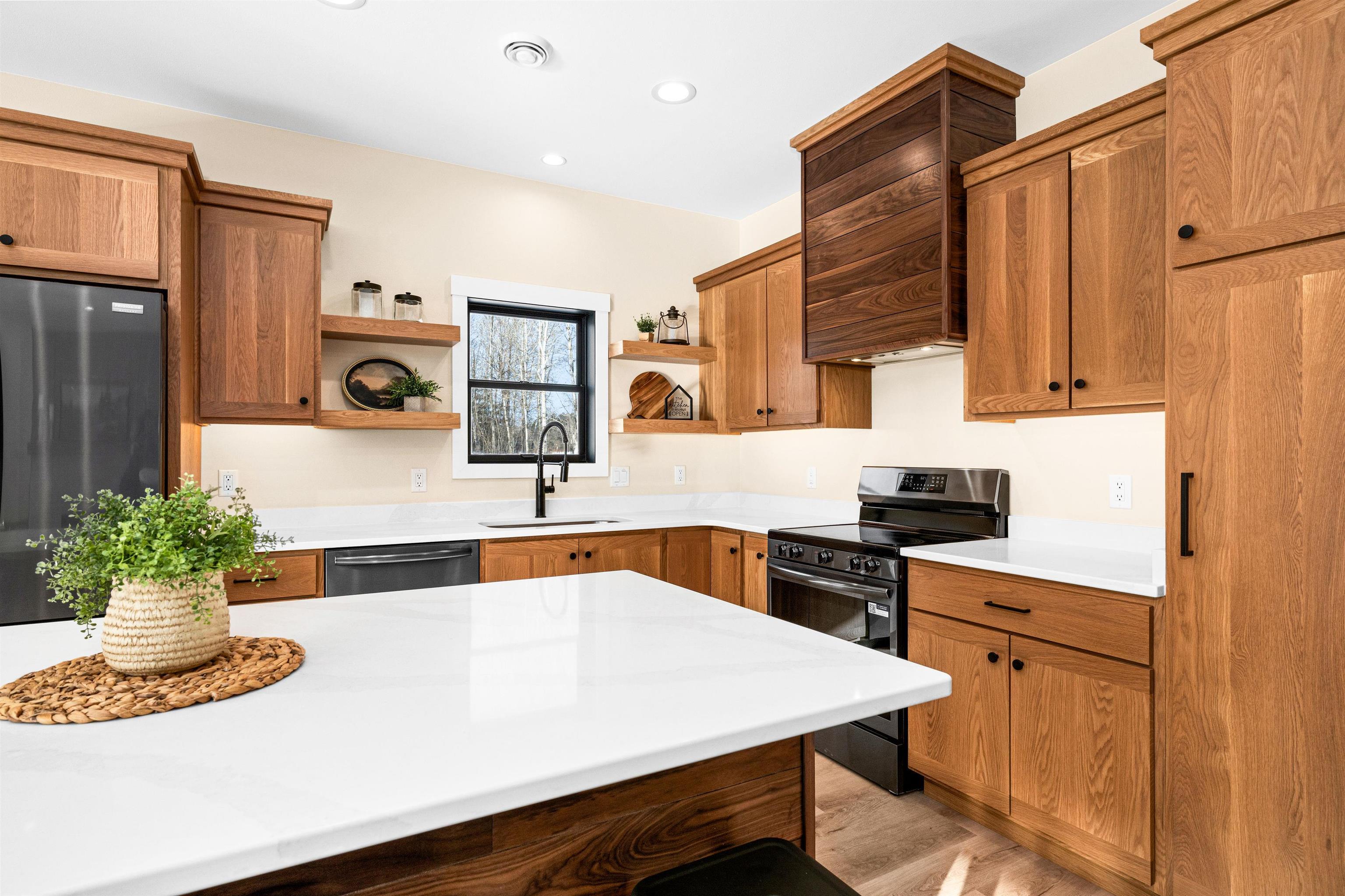 Image 1: Kitchen featuring appliances with stainless steel finishes, brown cabinetry, open shelves, light wood-style floors, and recessed lighting, Kitchen