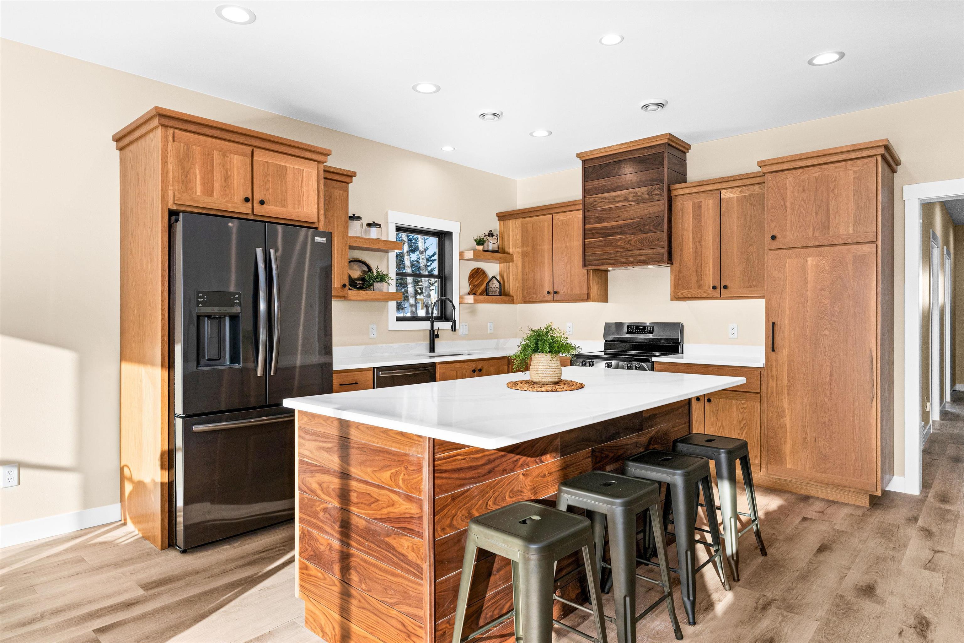 Image 1: Kitchen featuring fridge with ice dispenser, a breakfast bar, a kitchen island, open shelves, and light wood-style flooring, Kitchen