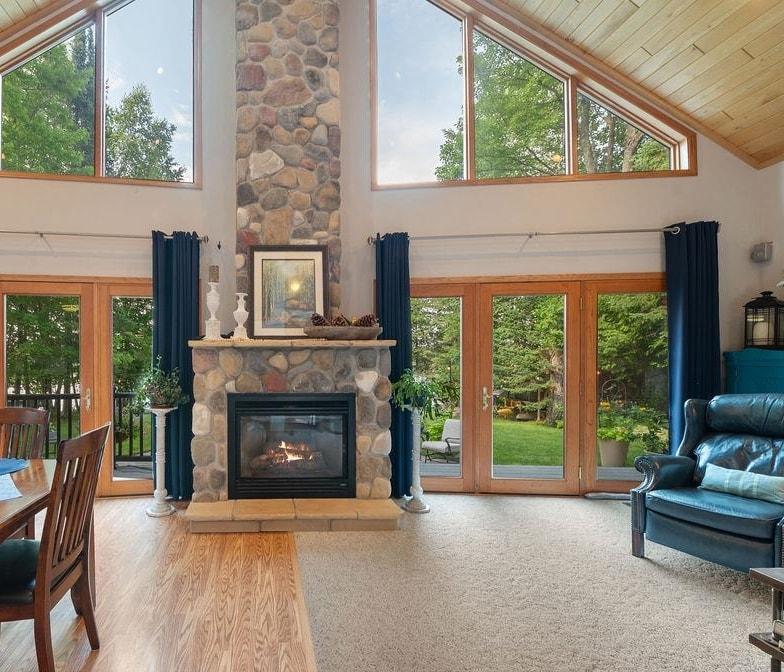 Image 3: Living room featuring wooden ceiling, a stone fireplace, french doors, wood finished floors, and high vaulted ceiling, Living Room
