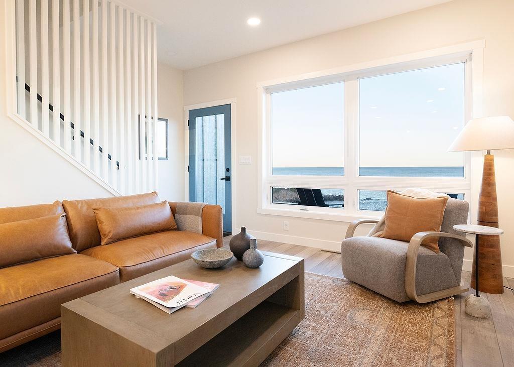 Image 1: Living room with wood finished floors, stairs, recessed lighting, and a water view, Living Room