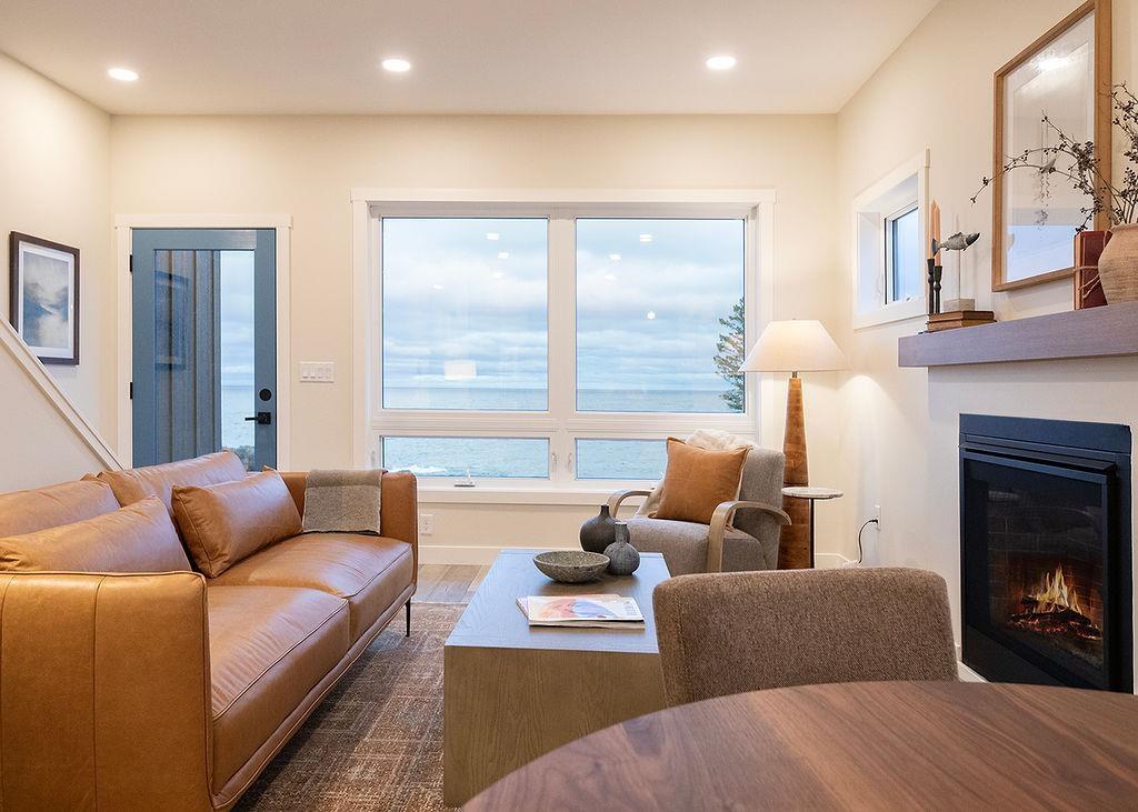Image 3: Living room featuring a glass covered fireplace, recessed lighting, and wood finished floors, Living Room