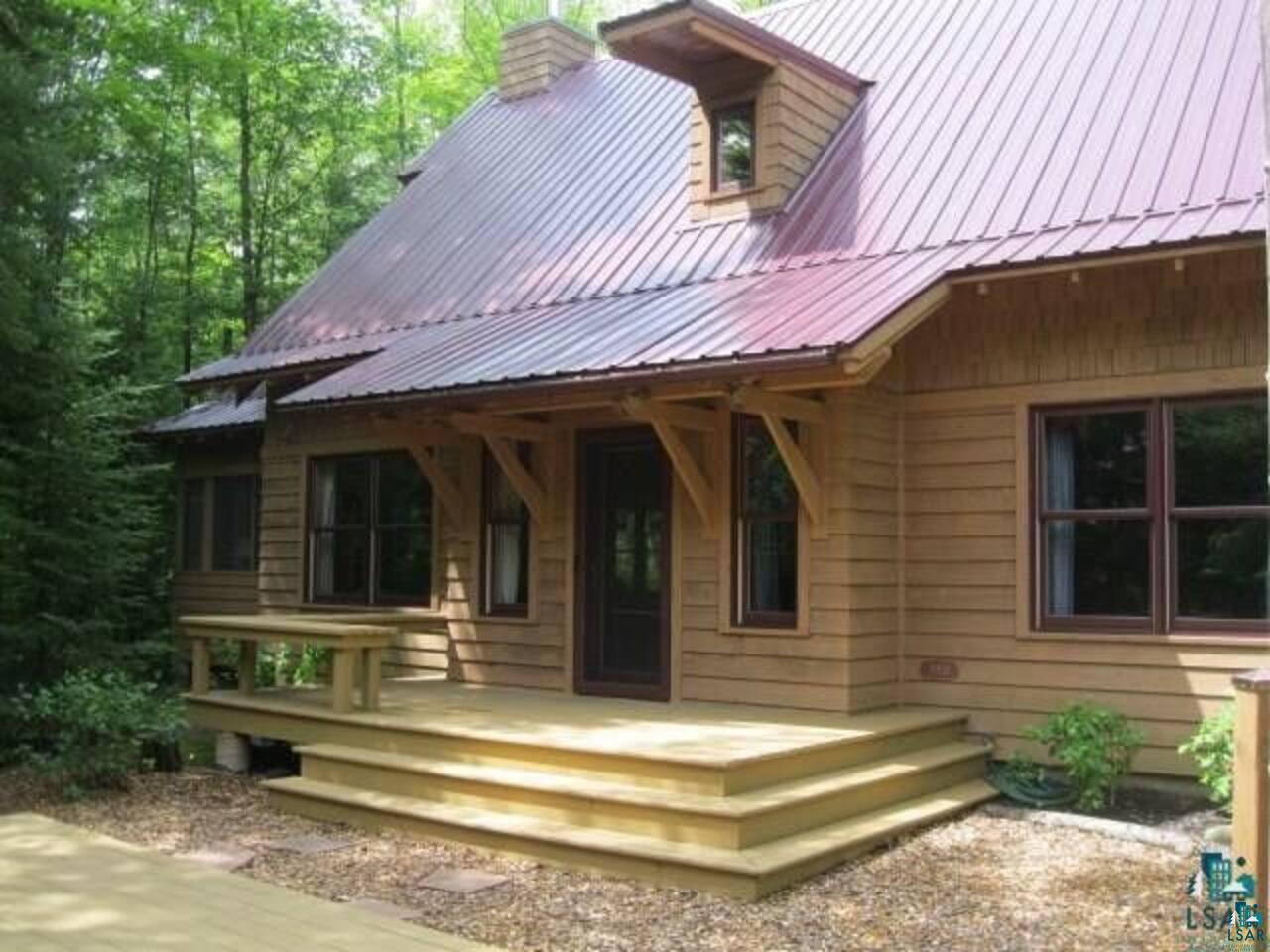 Image 0: Rear view of house featuring a chimney and a metal roof, Back Of Structure