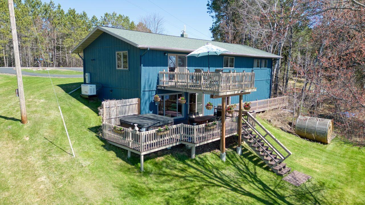 Image 0: Back of house with an exterior structure, a deck, stairway, a lawn, and an outdoor structure, Back Of Structure