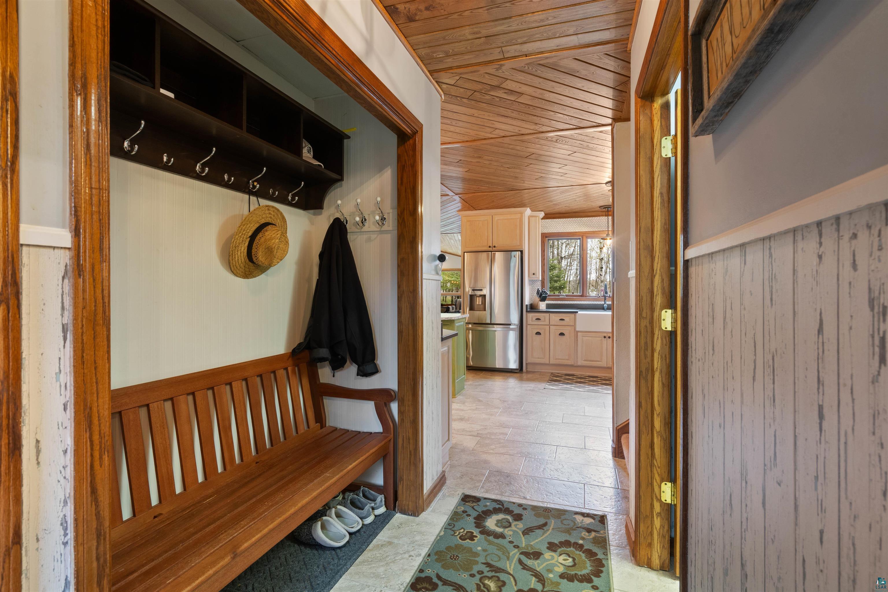 Image 2: Entryway mudroom featuring a built-in wooden bench, integrated coat hooks, and overhead shelving, Mud Room