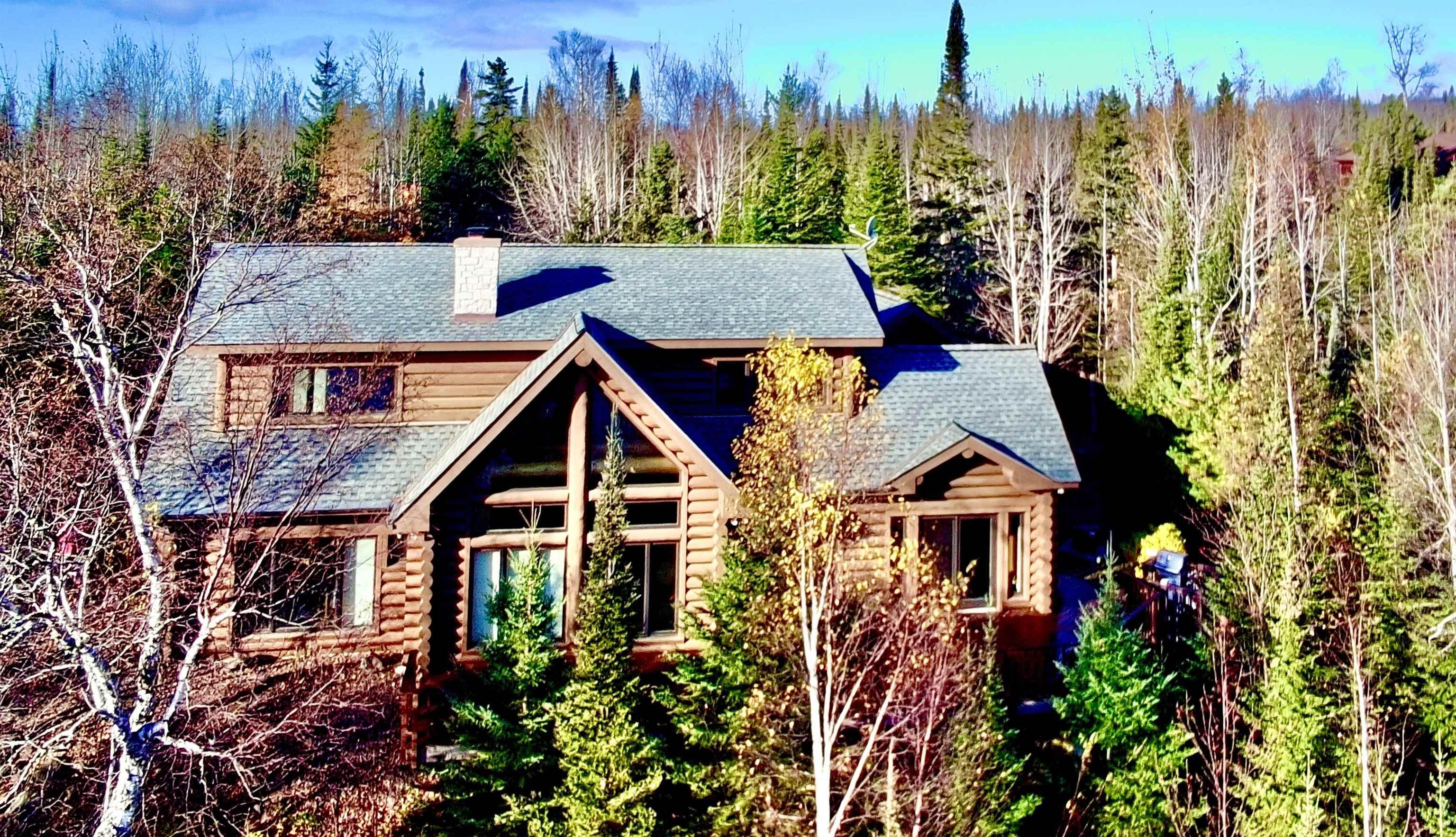 Image 0: Cabin featuring a chimney, roof with shingles, a forest view, and log exterior, Front Of Structure