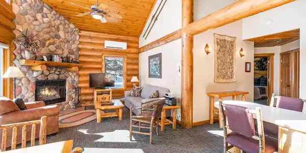 Image 2: Living room with rustic walls, a fireplace, a vaulted wood ceiling, carpet flooring, and ceiling fan, Living Room