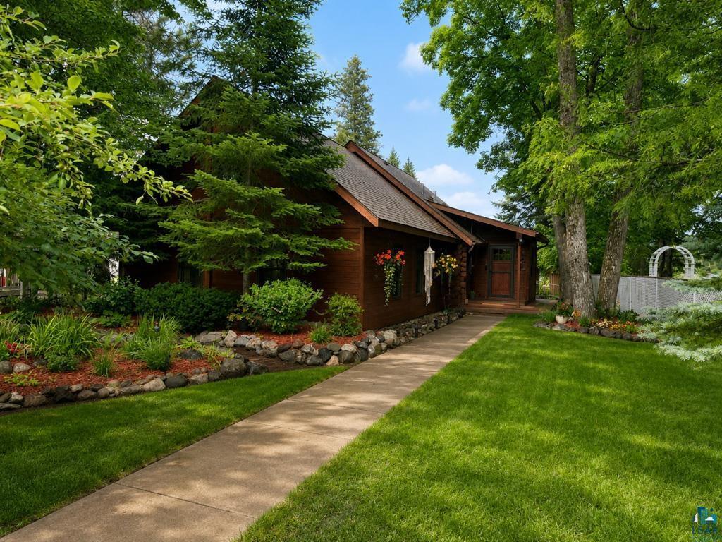 Image 3: Wood-sided exterior featuring a gabled roofline and stone foundation accents, Front Of Structure