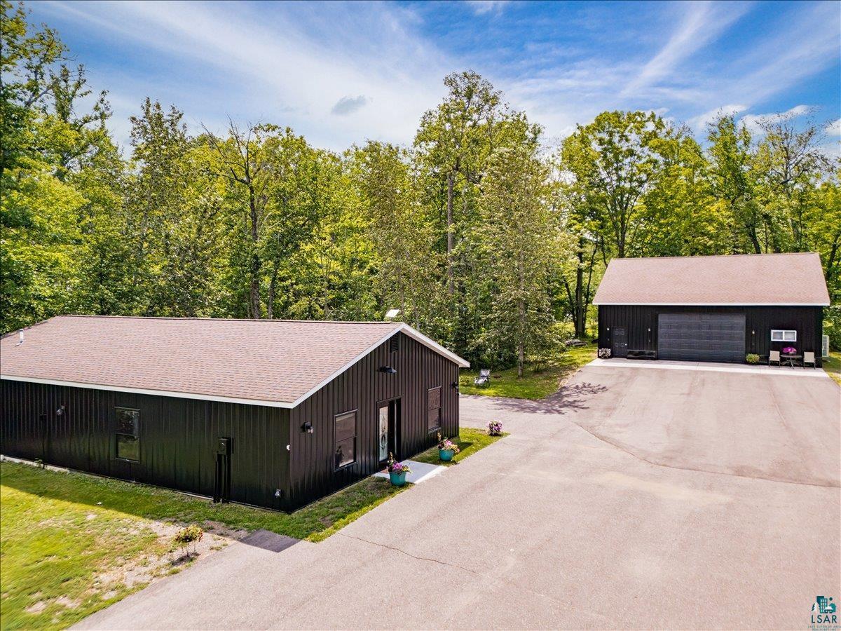 Image 0: Two dark-clad outbuildings with shingled roofs, Front Of Structure