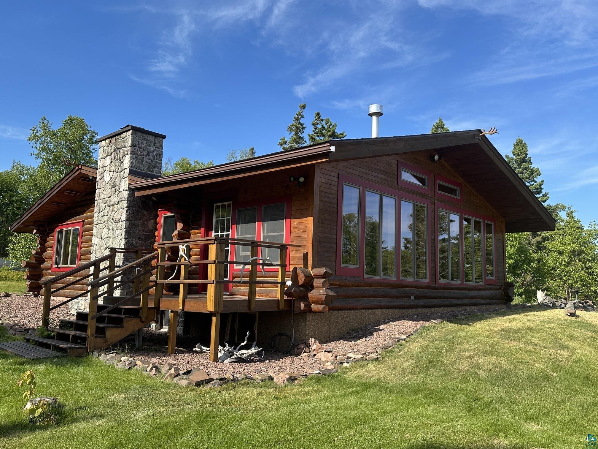 Image 0: Log cabin-style residence featuring a stone chimney, Back Of Structure