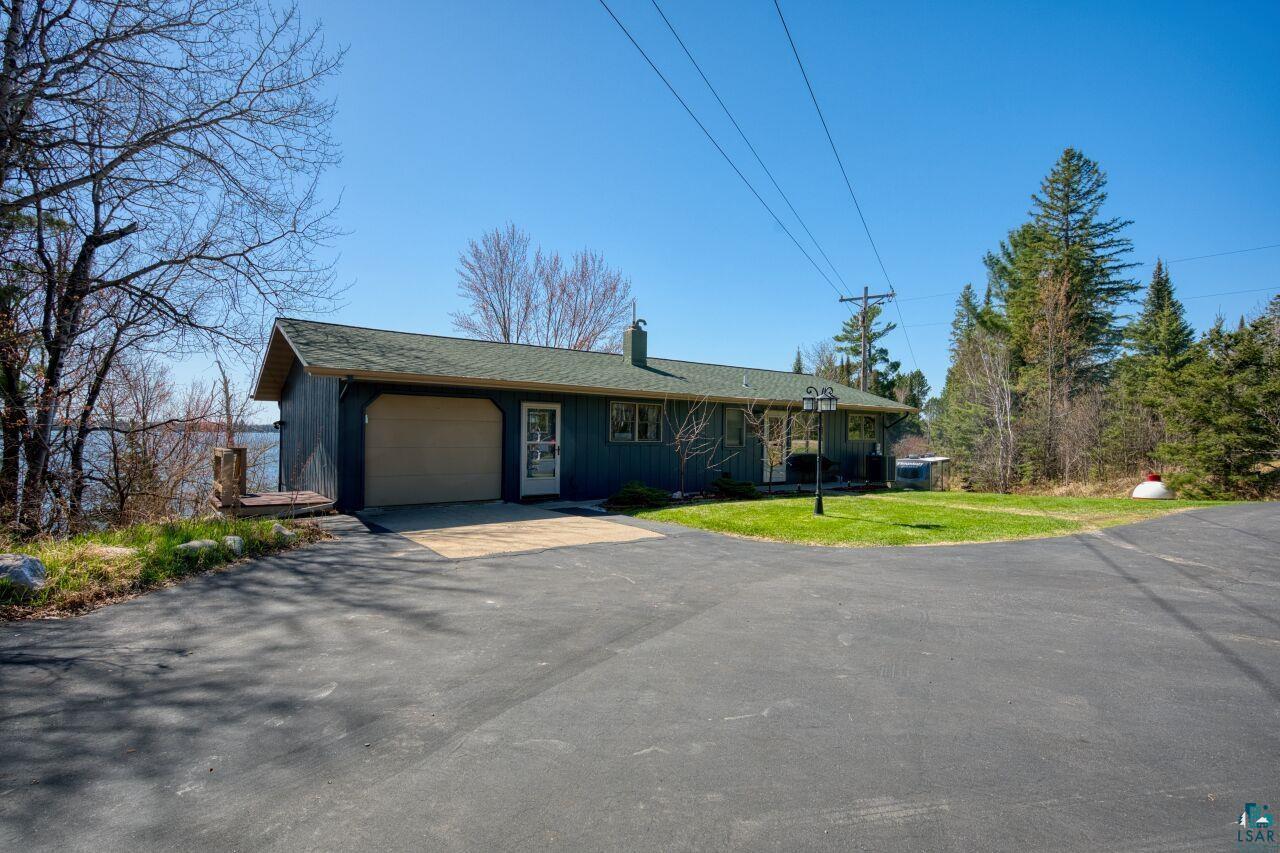 Image 2: Single story home with an attached garage, a chimney, aphalt driveway, board and batten siding, and a front yard, Front Of Structure