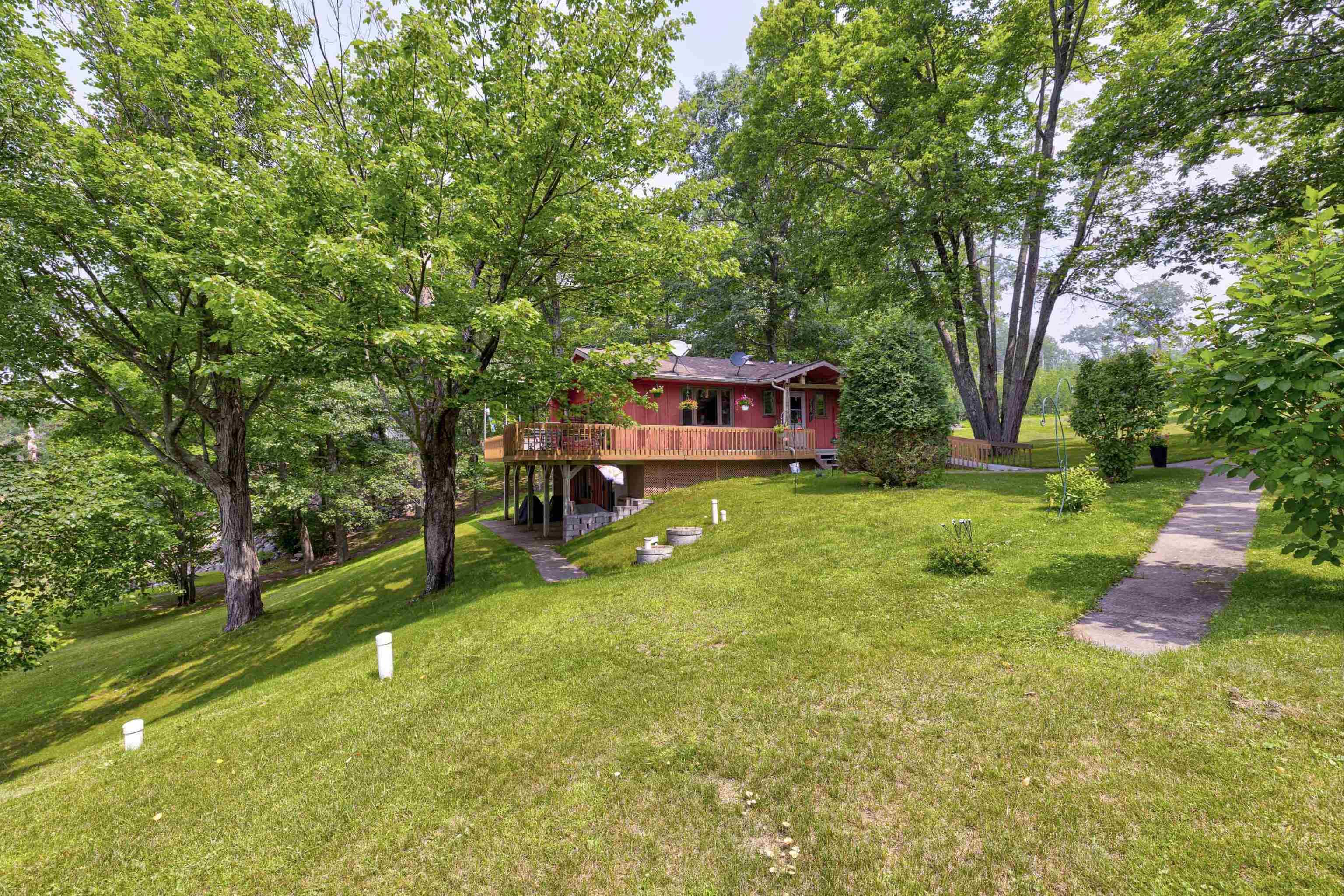 Image 2: View of green lawn with a deck, Yard