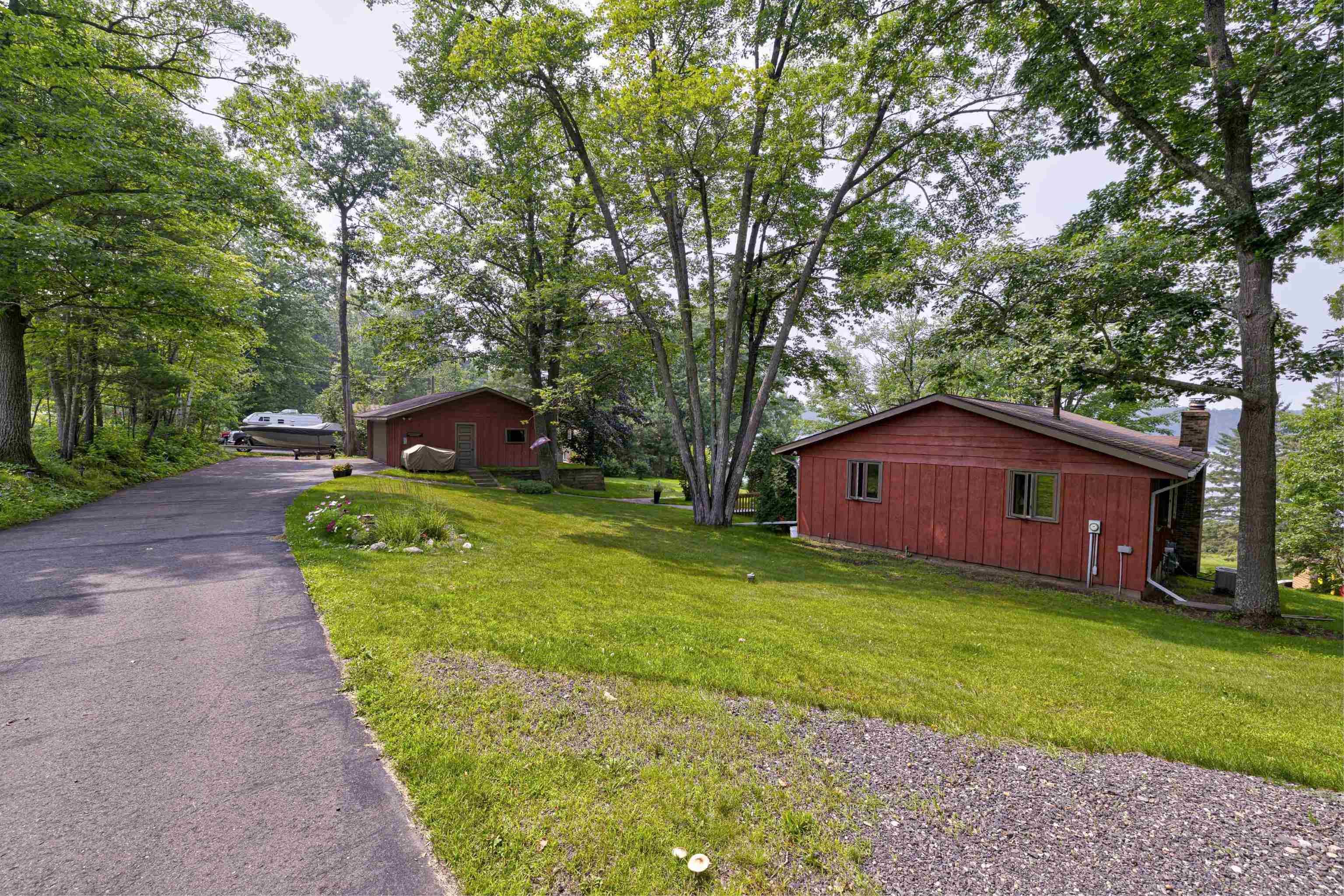Image 3: View of side of property featuring a lawn, view of scattered trees, and a chimney, Side Of Structure