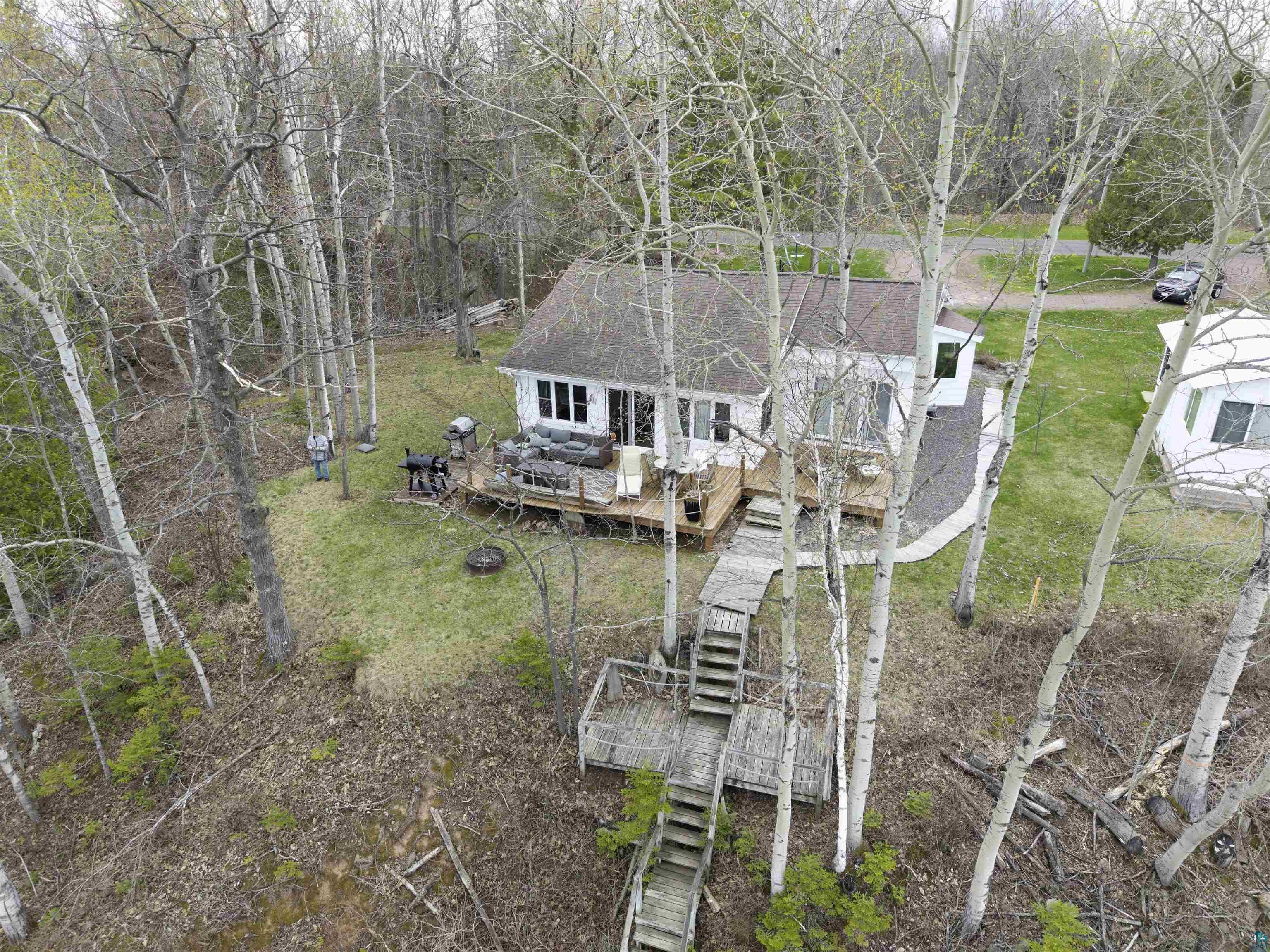Image 2: White-sided dwelling with a dark roofline, featuring a spacious outdoor deck, Aerial View