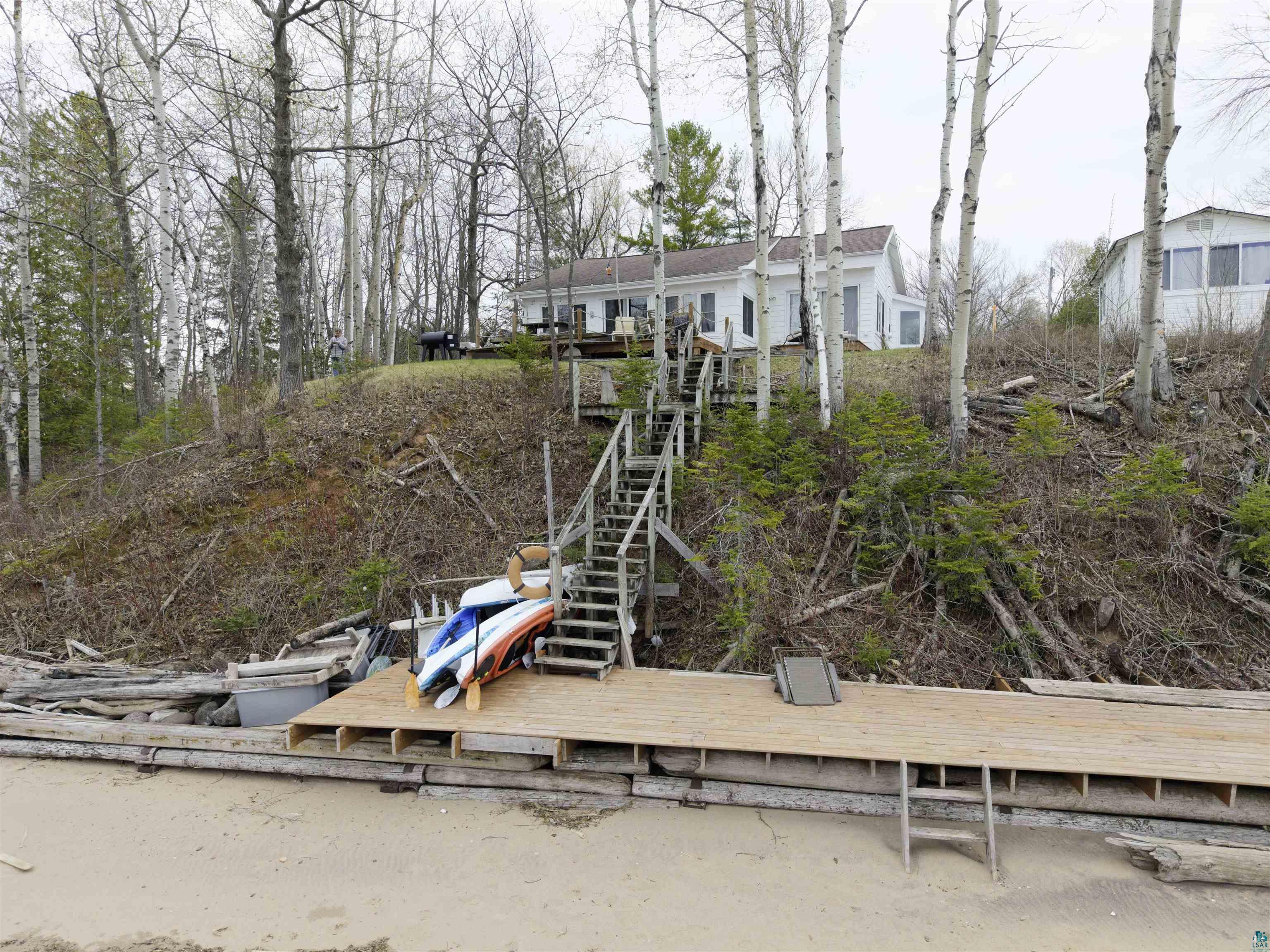 Image 3: Waterfront property featuring a sandy beach, private dock, and a multi-level staircase providing access to the main residence, Back Of Structure