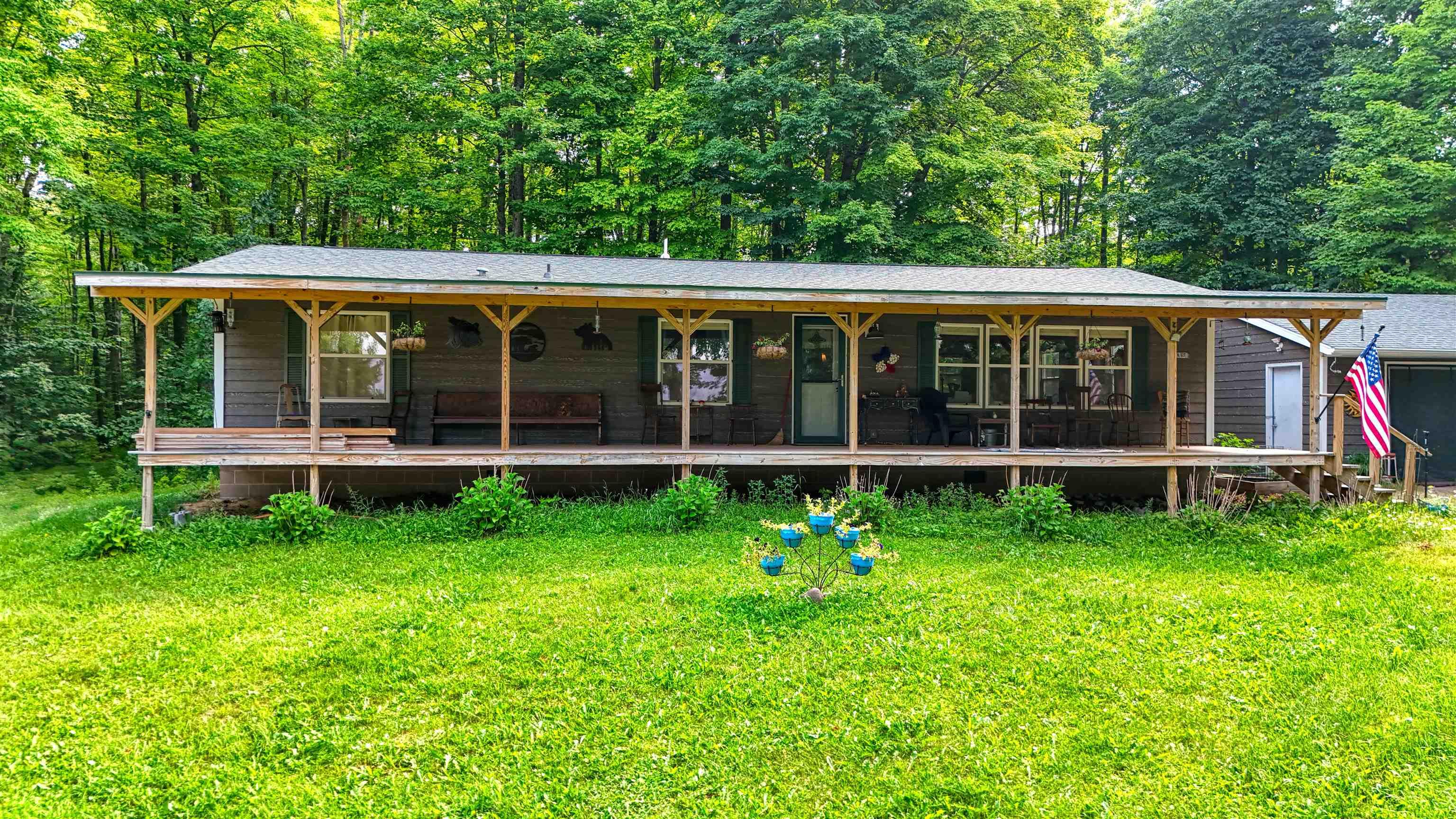 Image 1: View of front of property with covered porch, a front yard, and a shingled roof, Front Of Structure