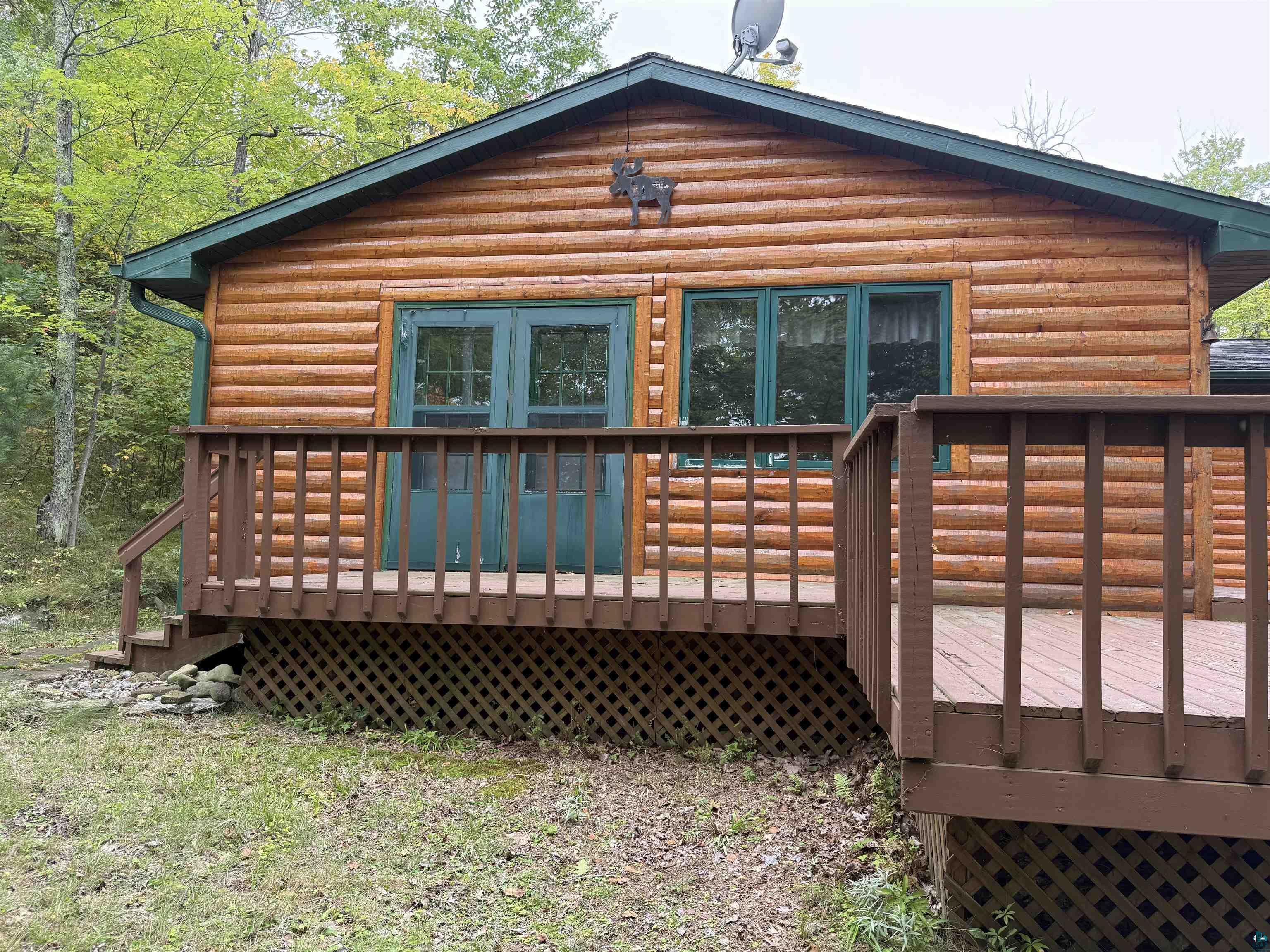 Image 1: Rear view of house featuring a deck and log veneer siding, Back Of Structure