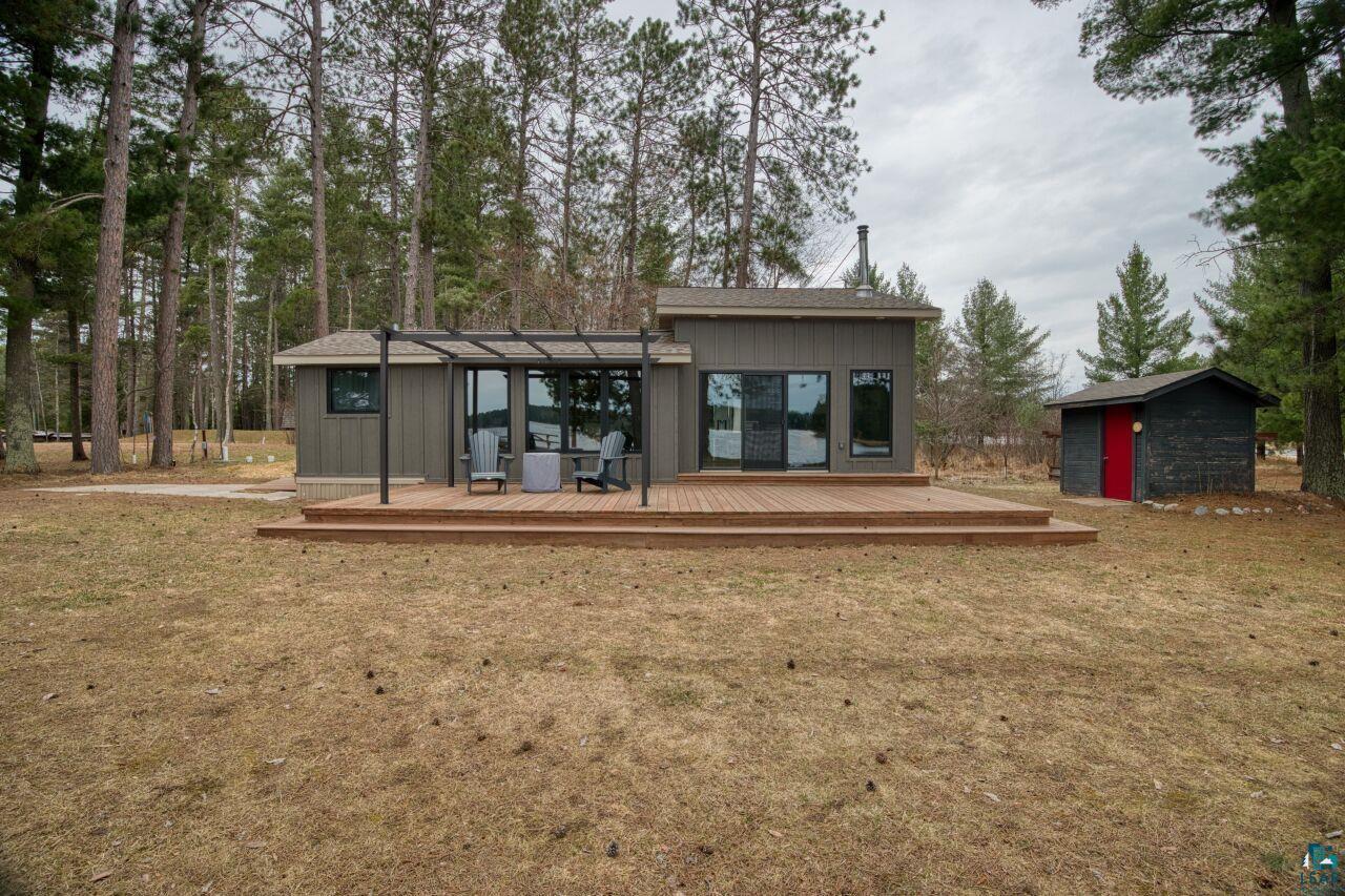 Image 2: Contemporary exterior with a spacious wood deck and integrated pergola structure, Back Of Structure