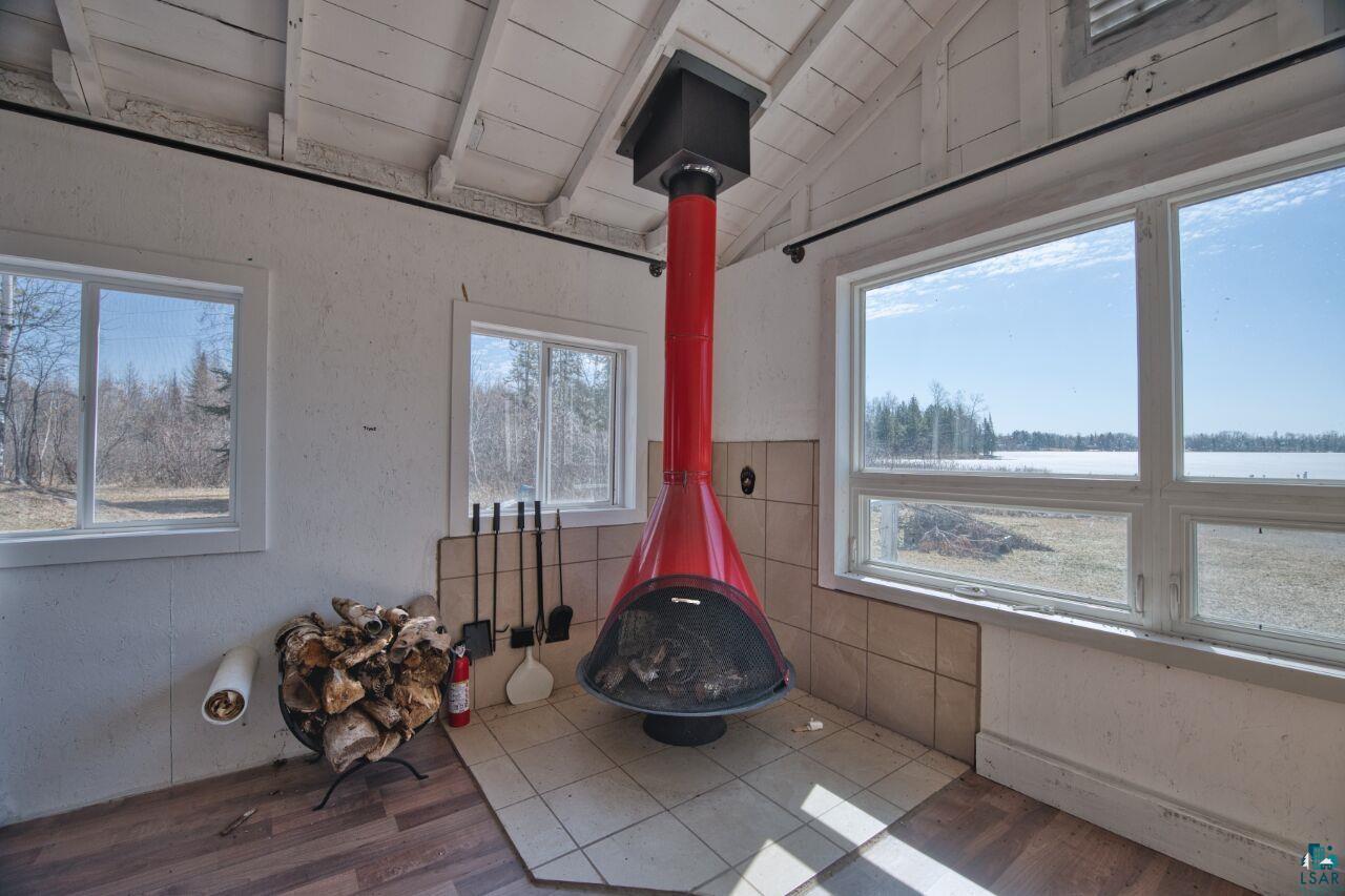 Image 3: Detailed view of wood finished floors, a wood stove, a textured wall, and wooden ceiling, Other