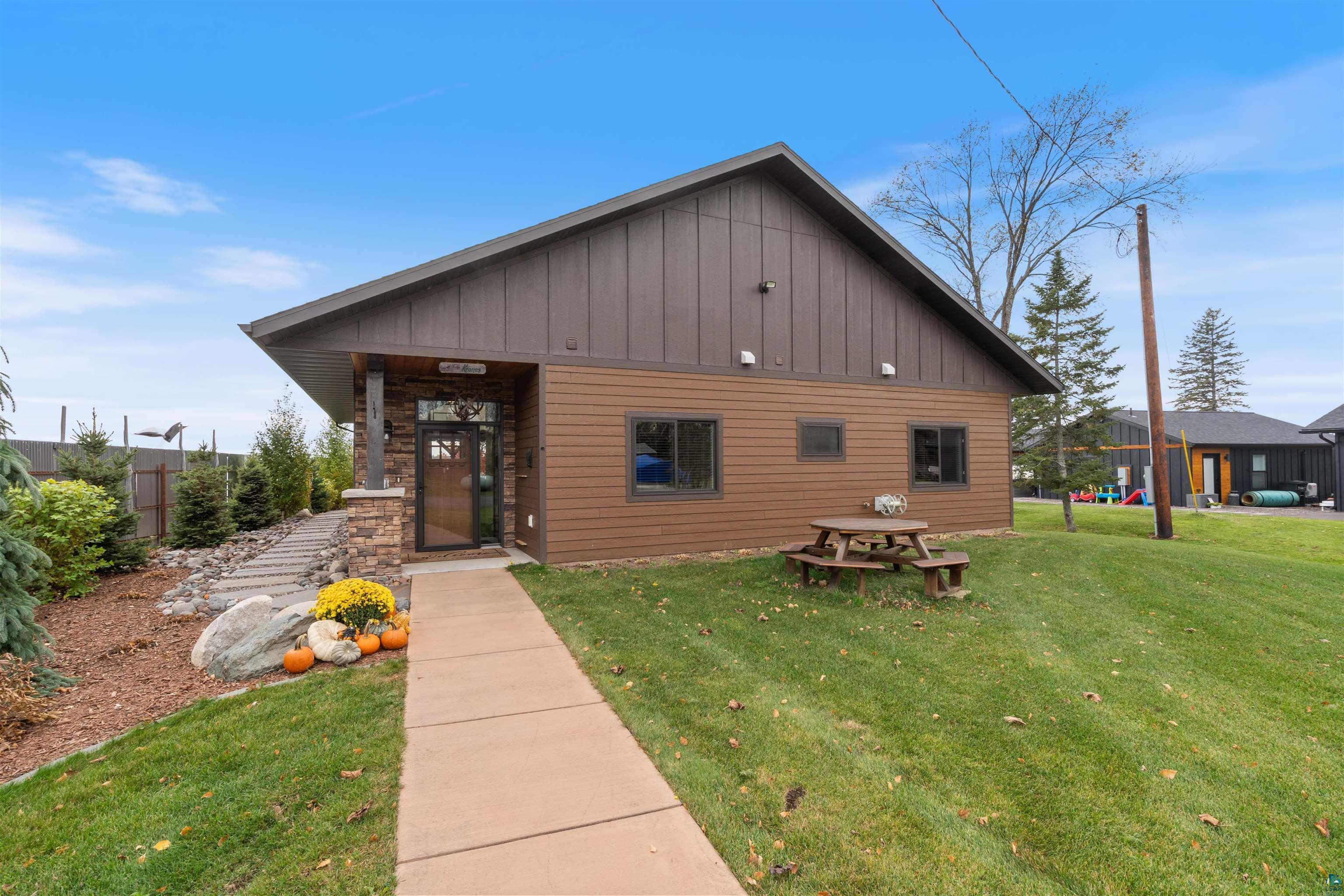 Image 1: View of front facade with board and batten siding and a front lawn, Front Of Structure