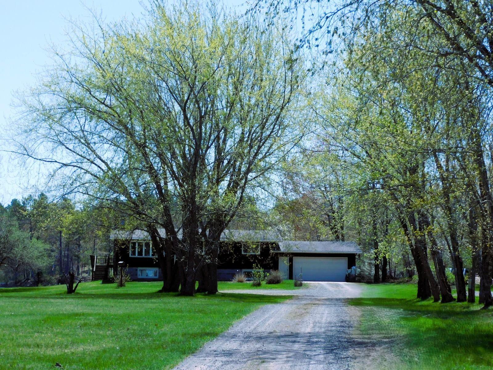 Image 2: View of front of property featuring dirt driveway, a garage, and a front yard, Front Of Structure