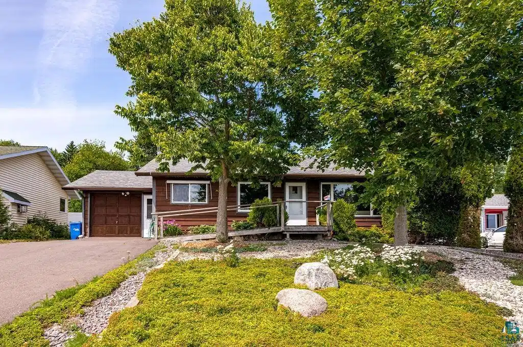Image 0: Exterior featuring wood siding, a paved driveway, and an attached garage, Facing Lake Superior
