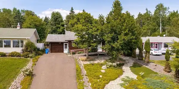 Image 2: Paved driveway leading to an attached garage & featuring a ramp entrance., Paved front driveway.