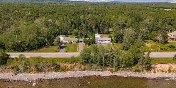 Image 3: Along Scenic North Shore while fronting Lake Superior property featuring a clear shoreline, expansive green space, and mature trees., Access to Lake Superior