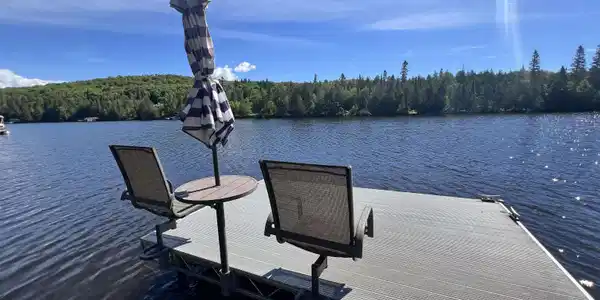 Image 2: Caribou Lake featuring a private dock with ample space and a serene natural backdrop of mature trees, Caribou Lake
