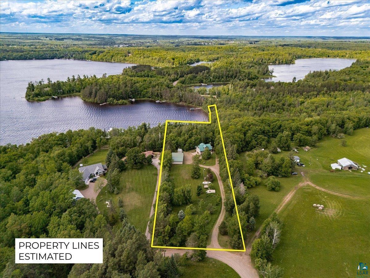 Image 2: Expansive property featuring waterfront access, mature trees, a private driveway, multiple structures, and surrounding natural landscapes, Aerial View