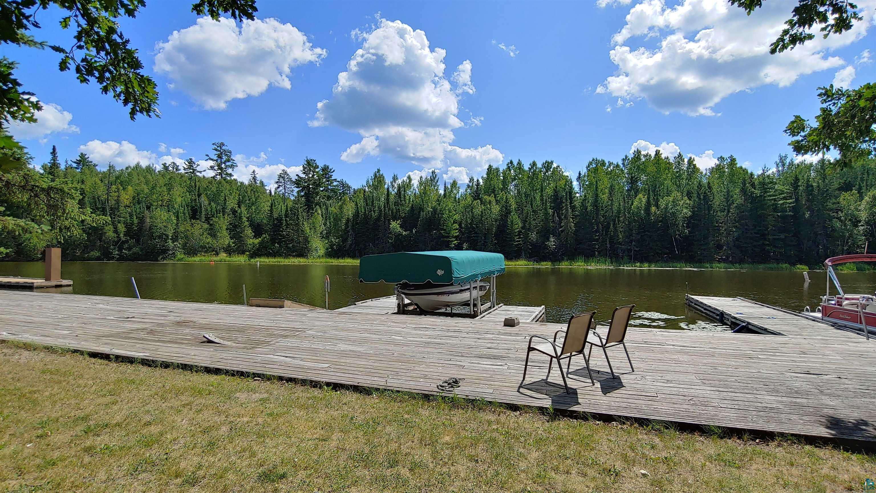 Image 3: Dock area with a water view, a view of trees, and a yard, Dock