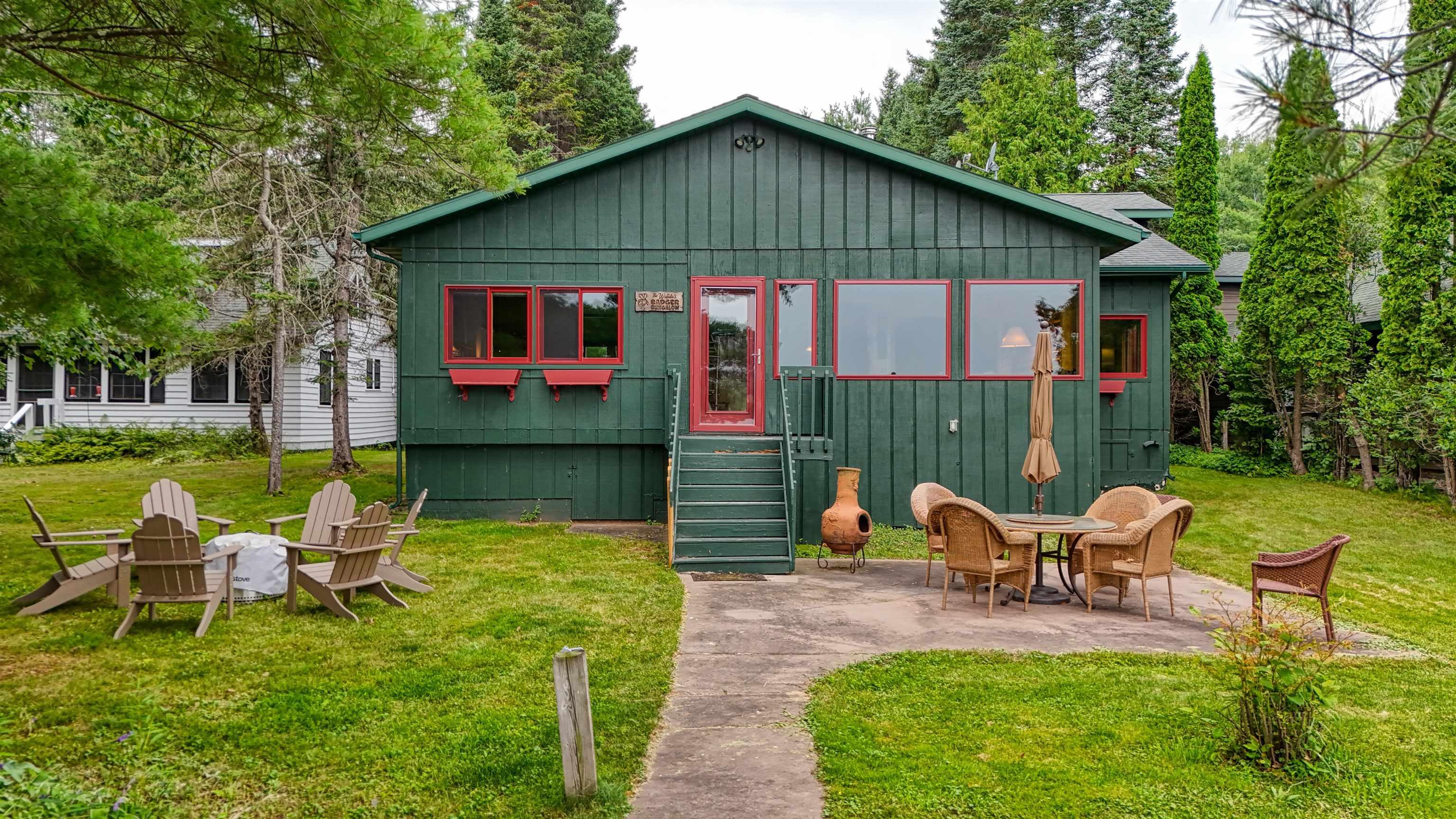 Image 1: Back of house with a patio area, a yard, and board and batten siding, Back Of Structure
