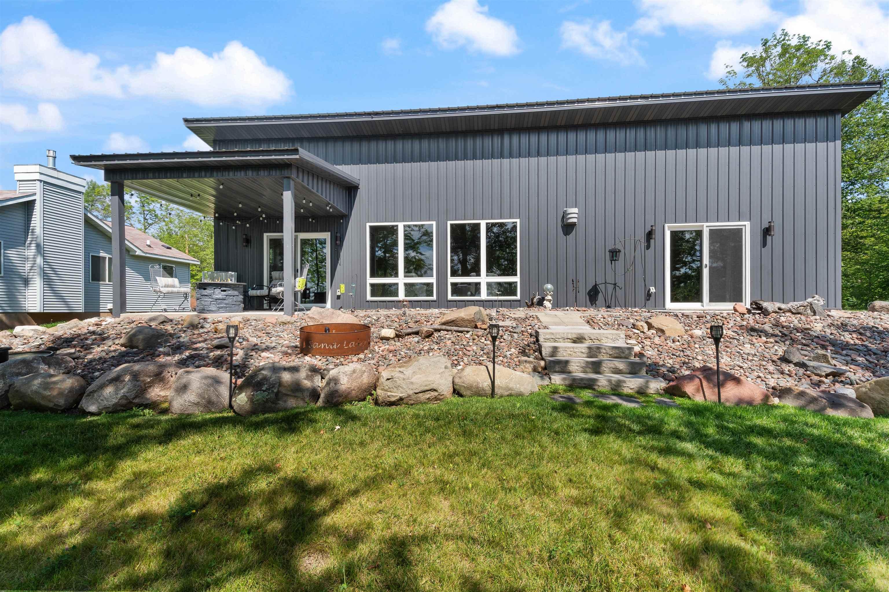 Image 3: Rear view of property featuring a patio area, board and batten siding, and a yard, Back Of Structure