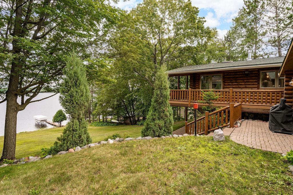 Image 1: View of green lawn featuring a deck and a patio, Yard
