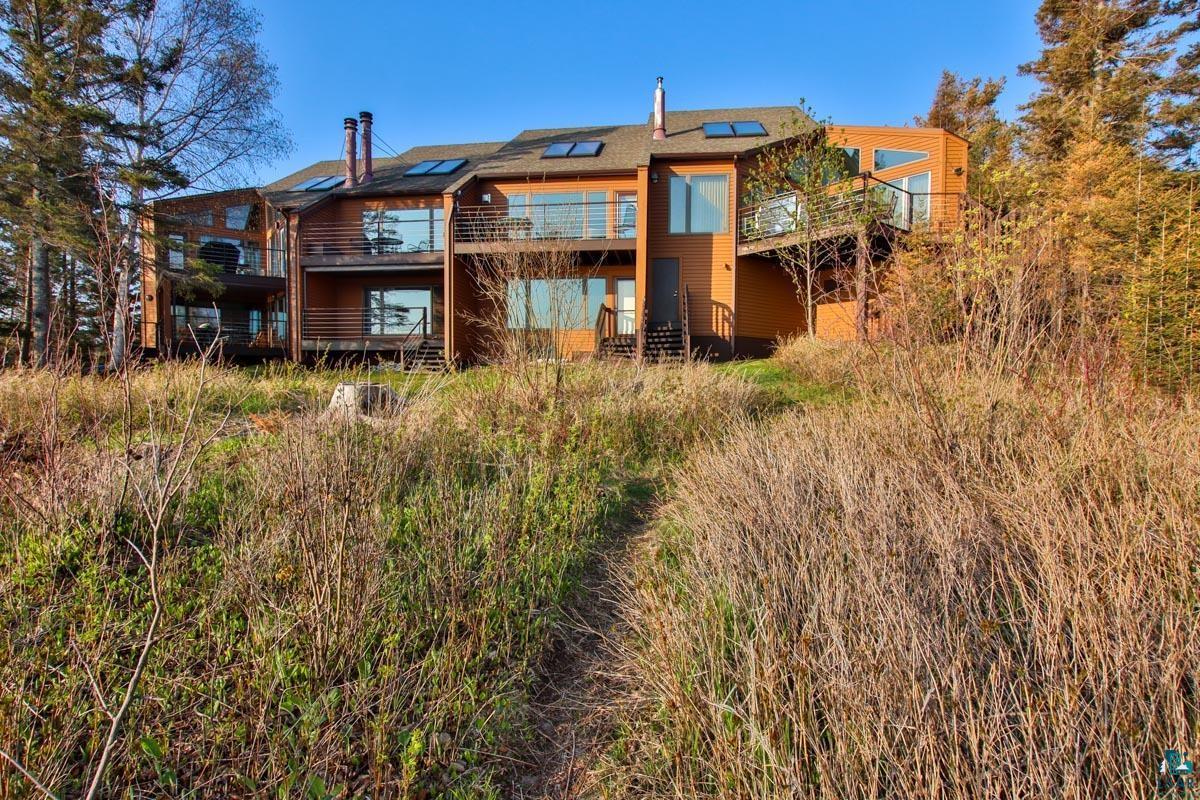 Image 0: Rear view of house with solar panels, a balcony, and a wooden deck, Back Of Structure