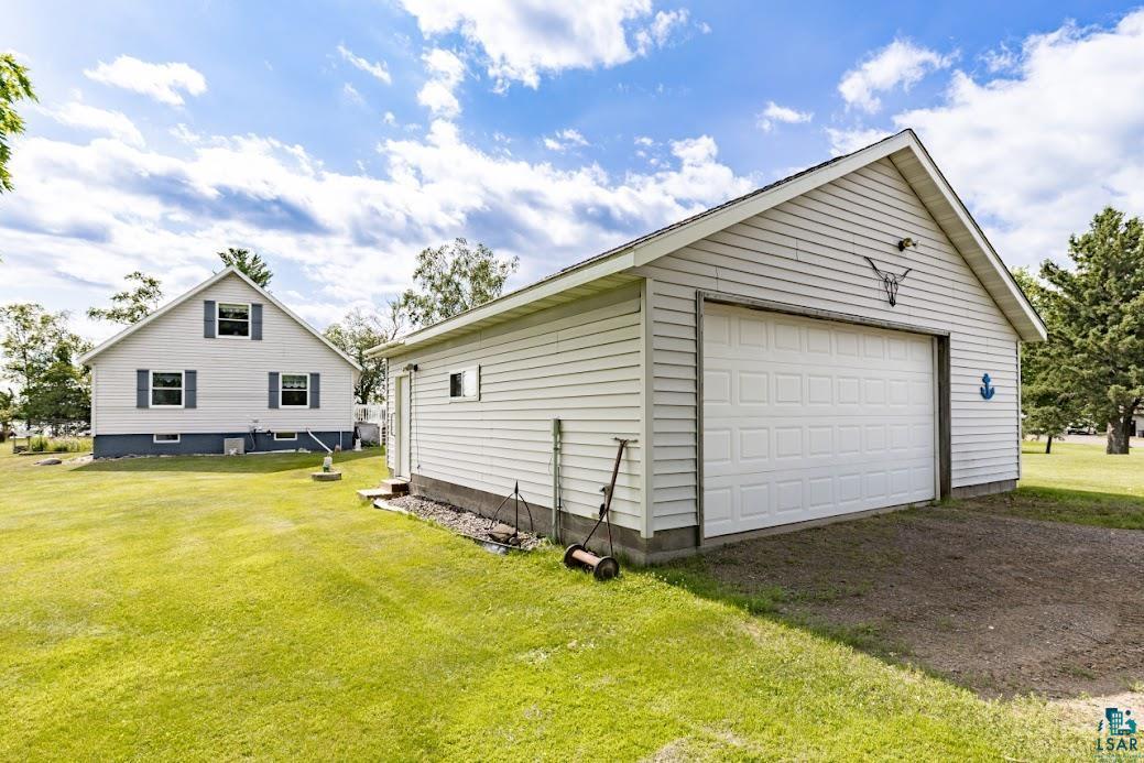 Image 2: Detached garage featuring white vinyl siding and a white panel garage door, Garage