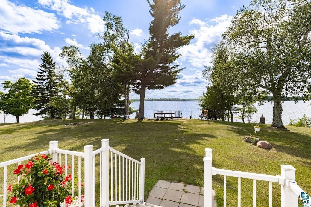 Image 3: Expansive grassy yard leading to a tranquil lakefront, Yard