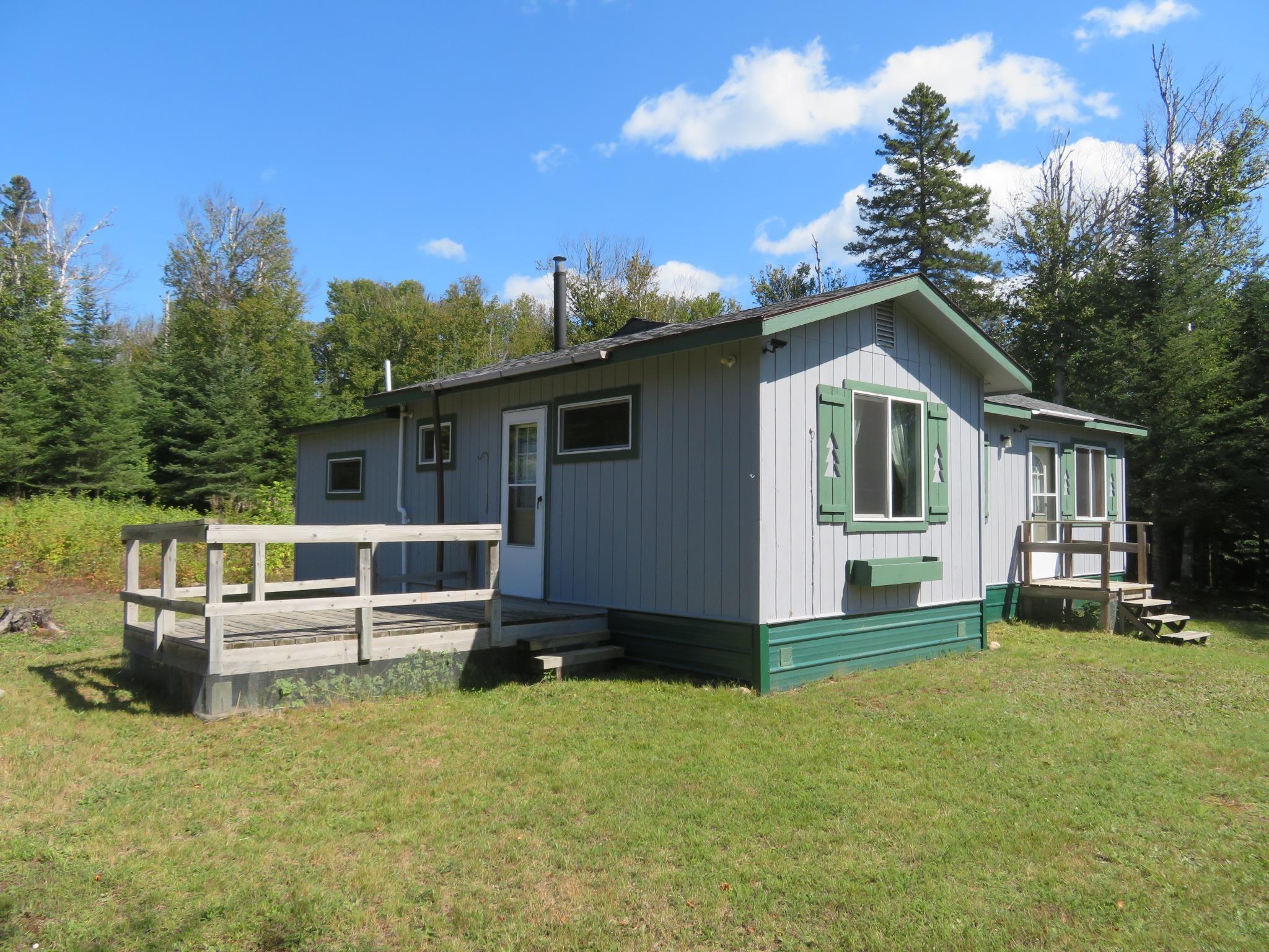 Image 0: View of front of house featuring a front lawn and a wooden deck, Front Of Structure