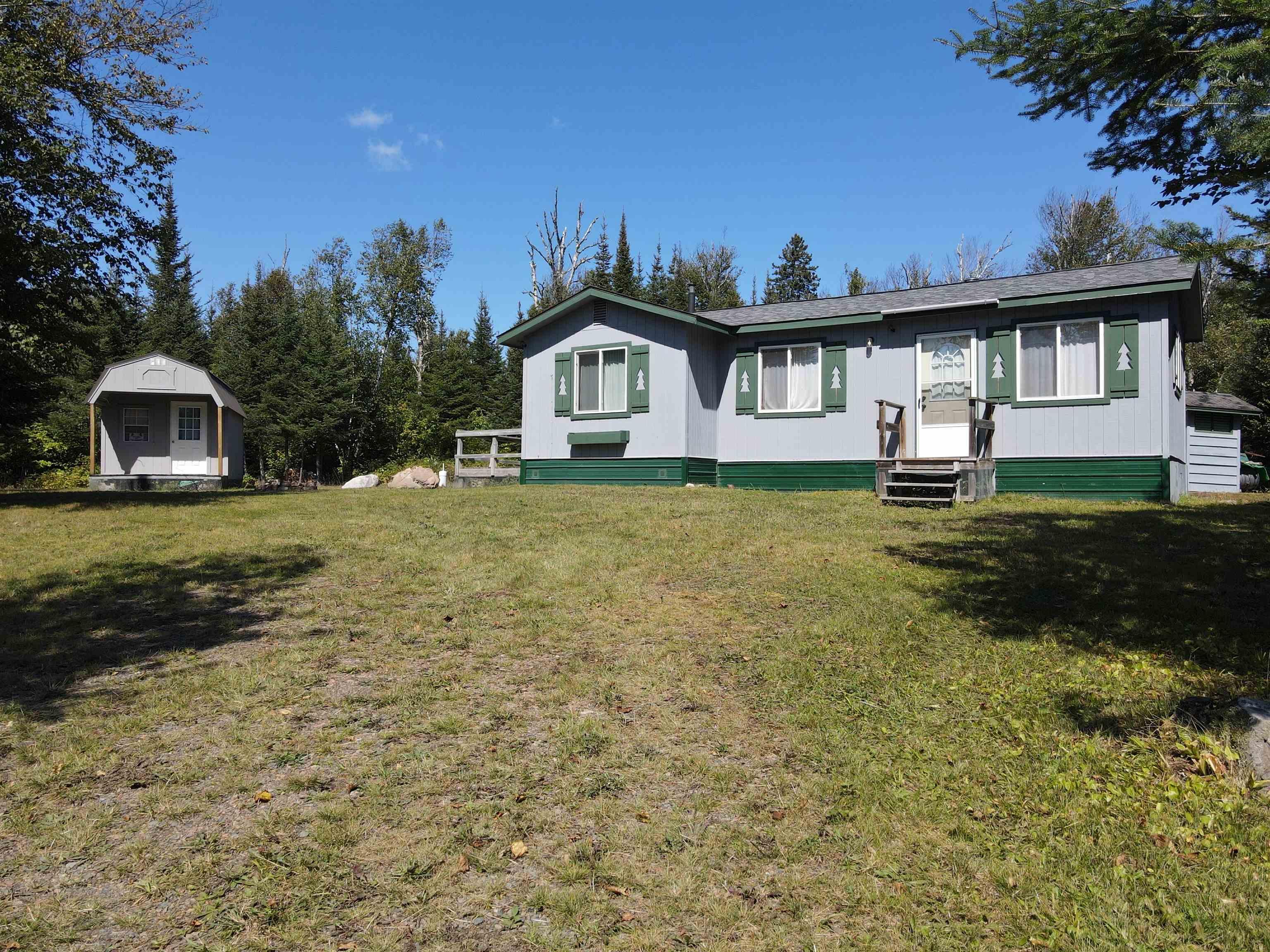 Image 1: View of front of home featuring a storage shed and a front lawn, Front Of Structure