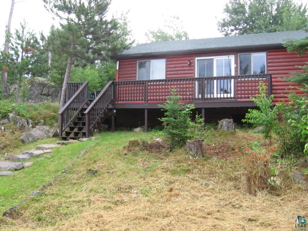 Image 0: view of property with log veneer siding, a deck, stairs to dock, Lakeside