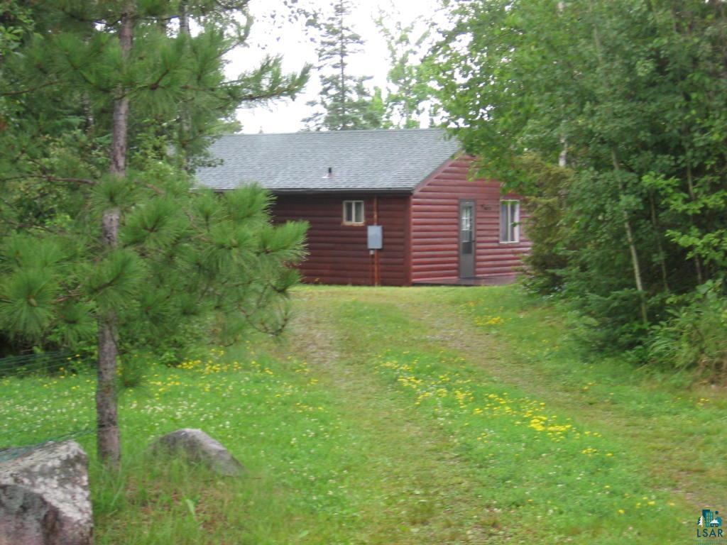 Image 3: View of side of home with faux log siding, roof with shingles, and a yard, Side Of Structure