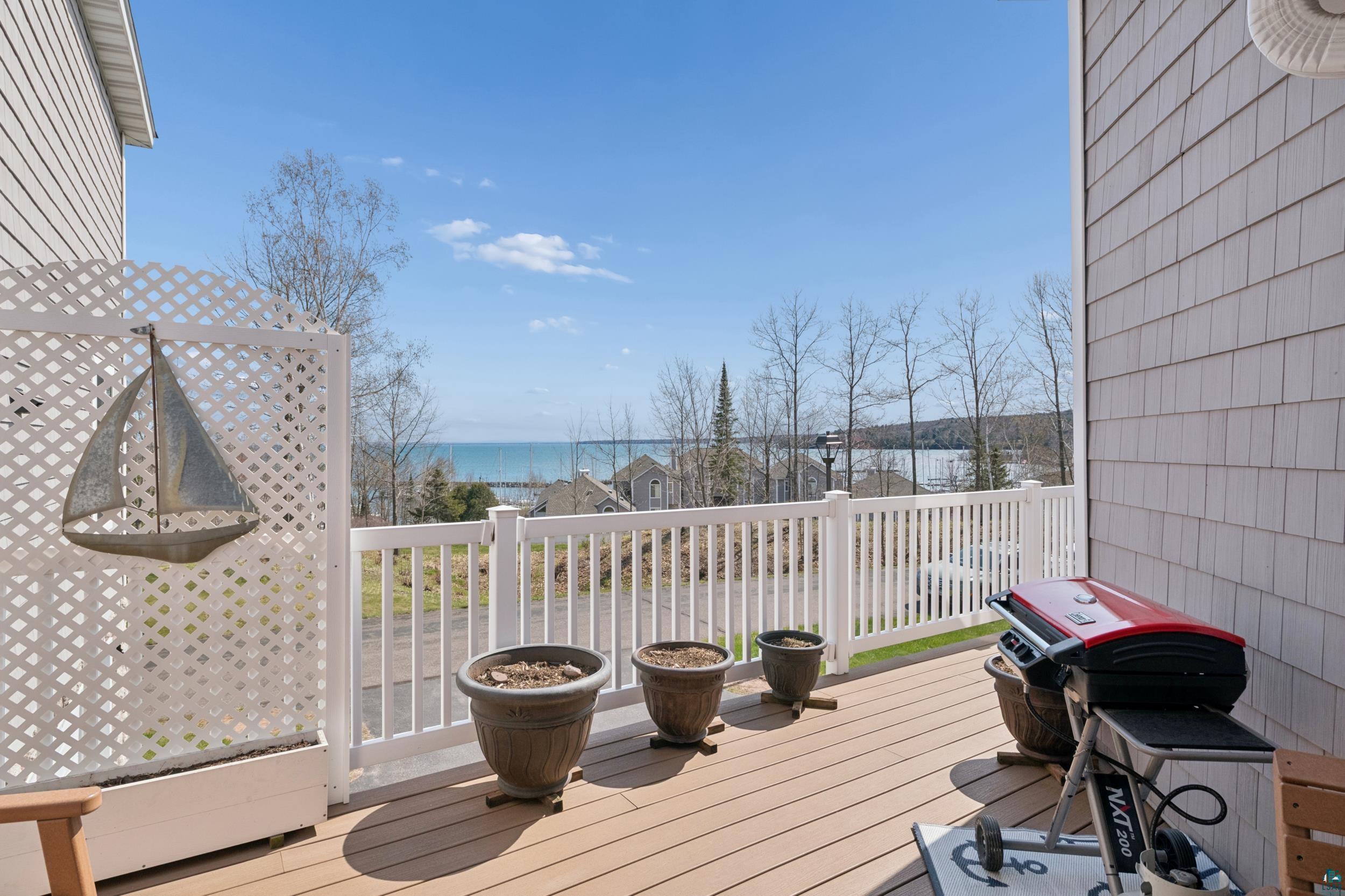 Image 1: Composite wood-finish decking with white railings and lattice privacy screen, Deck