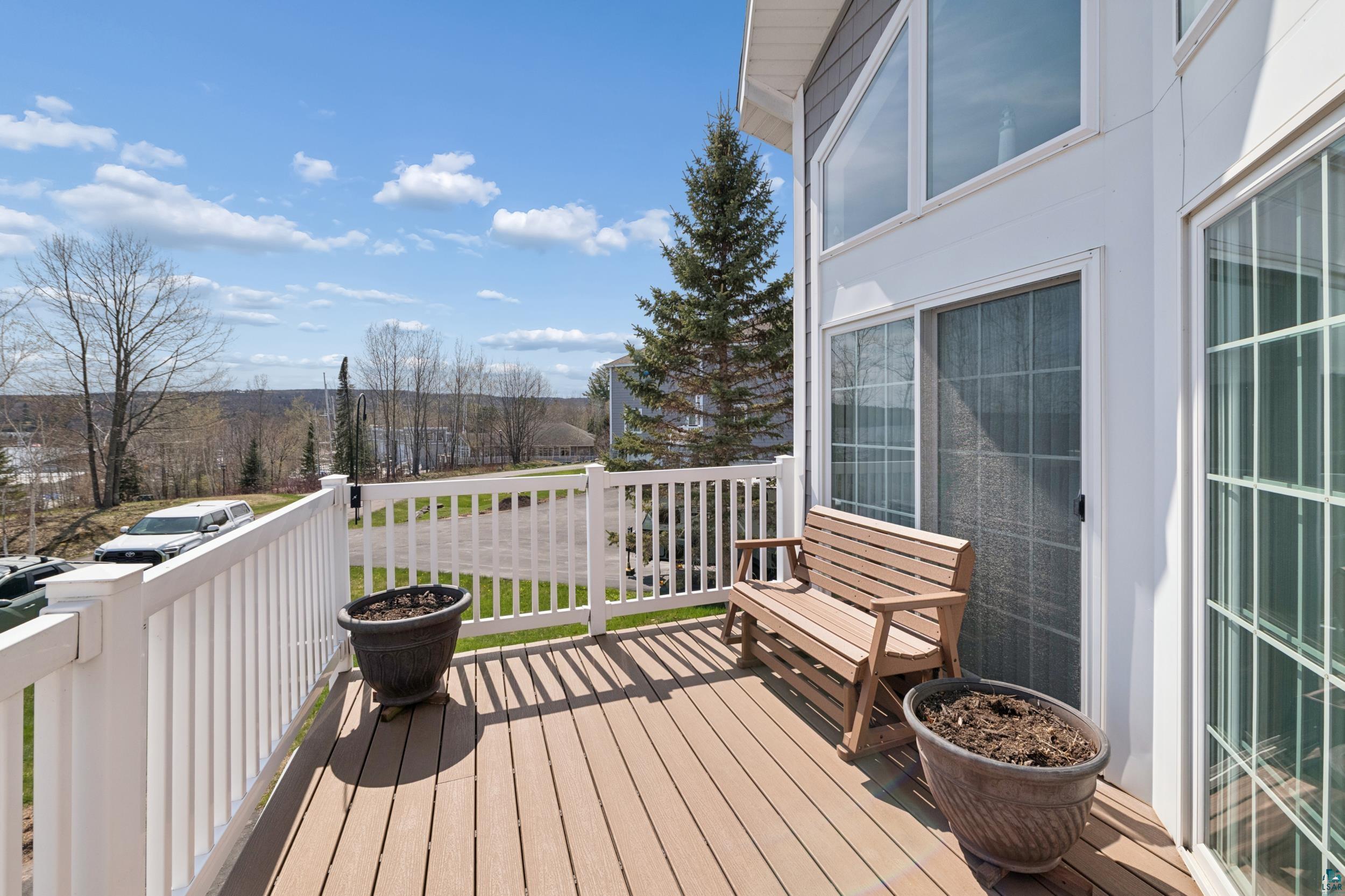 Image 2: Expansive outdoor deck featuring wood-finish flooring and white railings, Deck
