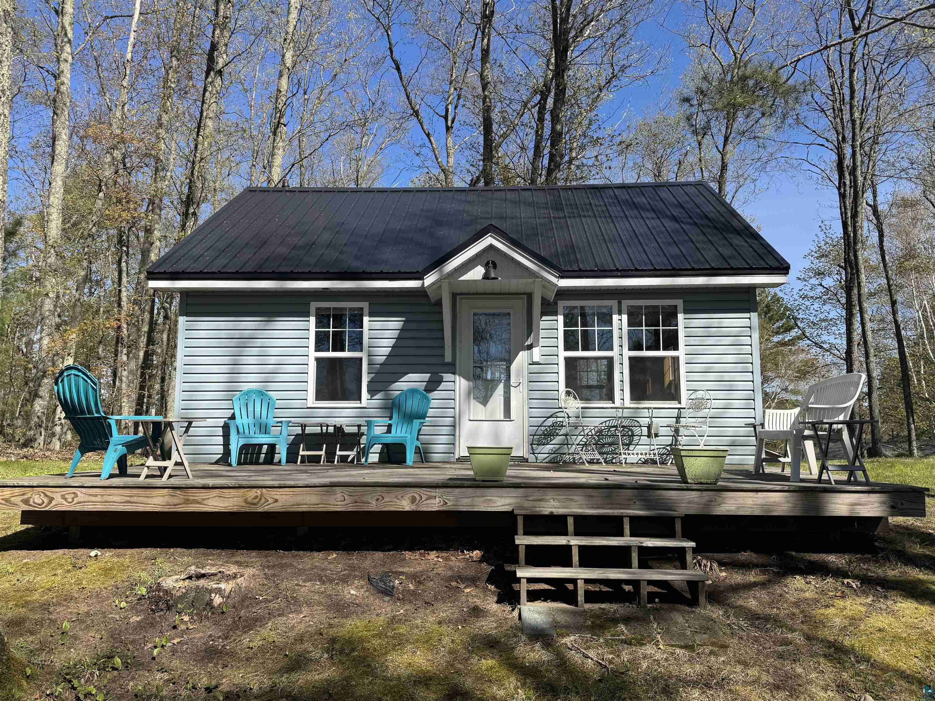 Image 0: Light blue siding exterior with a dark metal roof, Back Of Structure